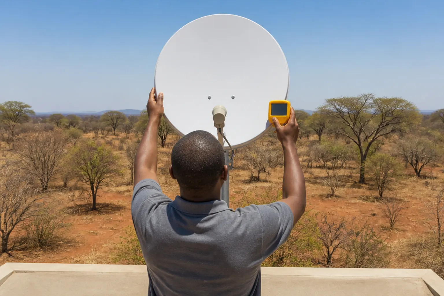 Technician aligning a satellite dish for a DStv installation in Balule